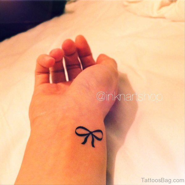 Black Ink Bow Tattoo On Wrist
