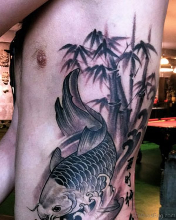 Grey Ink Fish And Bamboo Tree Tattoo On Side Rib