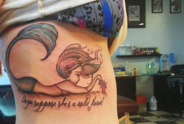 Lying Little Mermaid And Wording Tattoos On Rib