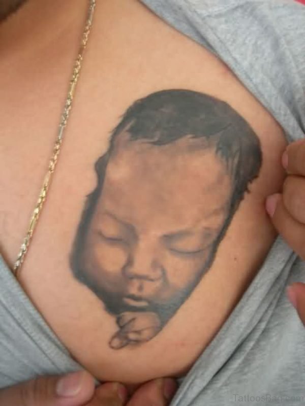 Showing Sleeping Baby Portrait Tattoo On Chest