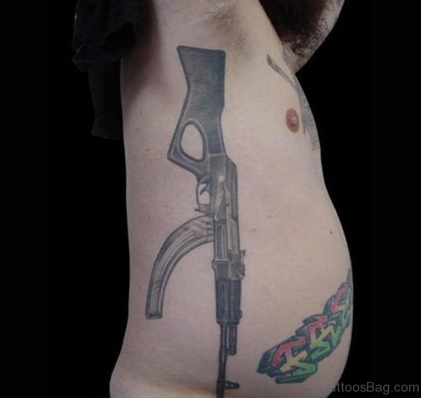 Amazing Grey Ink Gun Tattoo On Man Rib Side