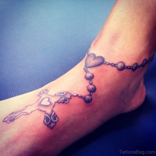 Attractive Grey Ink Cross Rosary Tattoo On Ankle