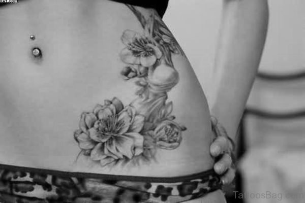 Belly Piercing And Flower Tattoo On Waist