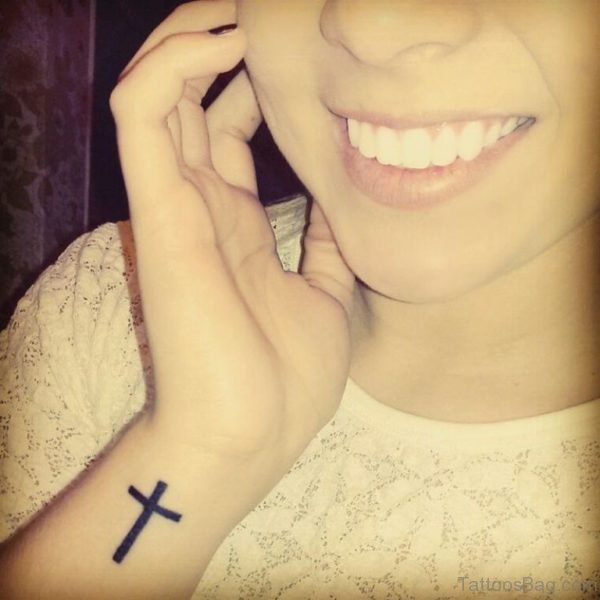 Smiling Girl With Black Cross Wrist Tattoo